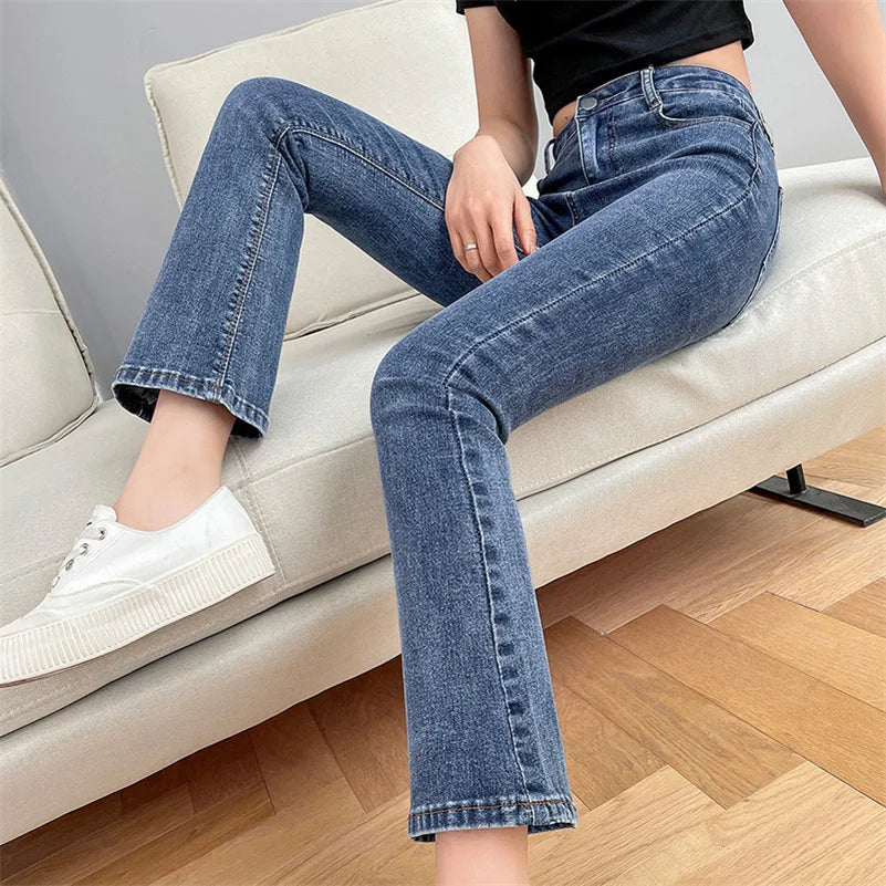 Person wearing blue jeans sitting on a beige sofa.