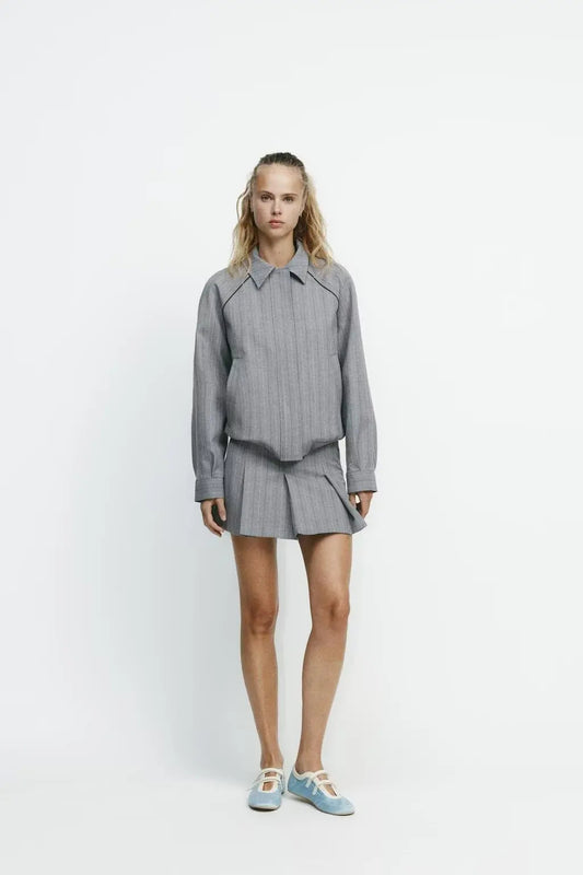 Woman wearing a gray outfit with a white background