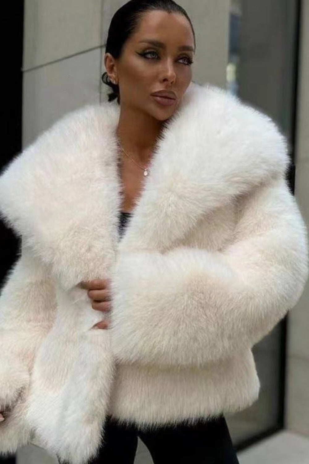 Woman wearing a white fluffy coat in an urban setting
