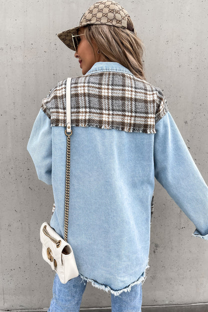 Person wearing a denim jacket with plaid pattern and Gucci cap against a gray wall.