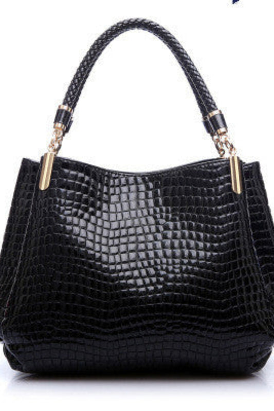 Black textured handbag with gold accents on a white background
