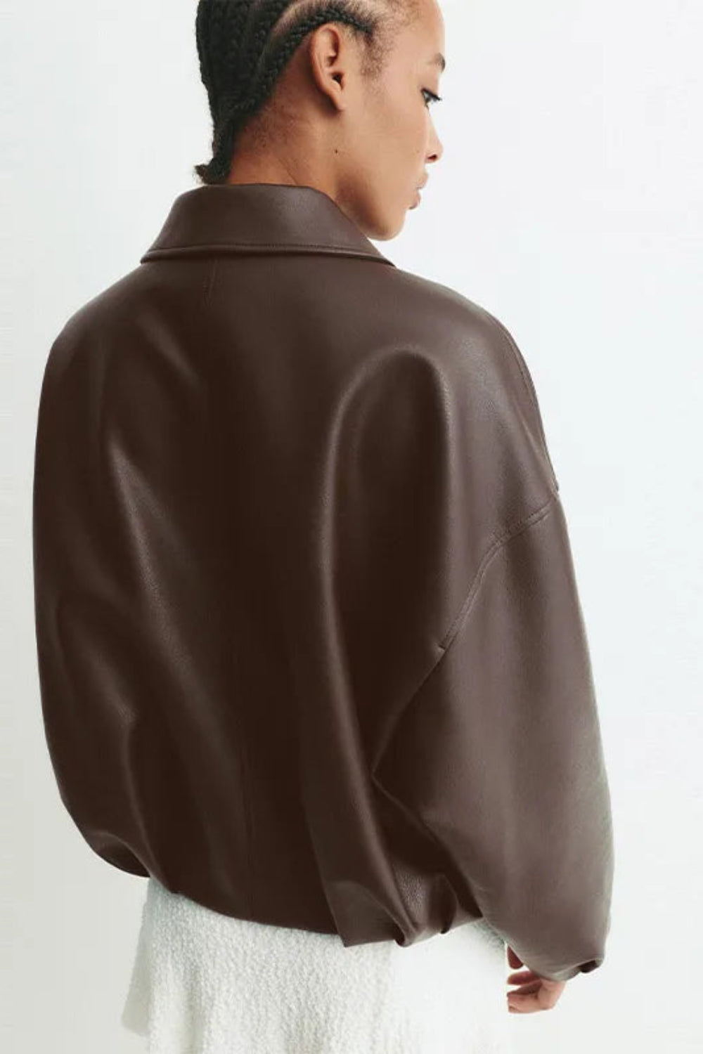 Person wearing a brown leather jacket on a white background