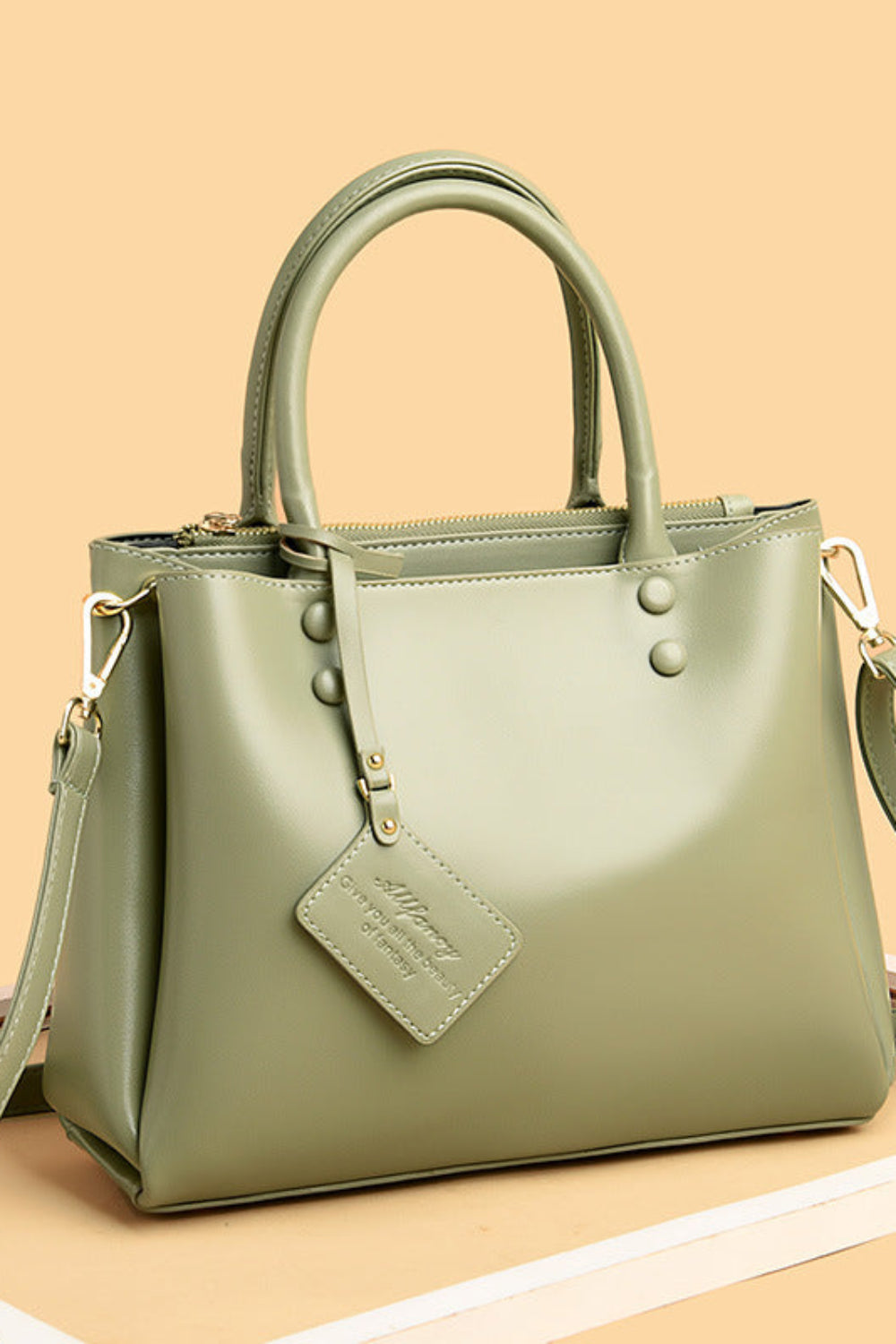 Green handbag with a strap on a beige background