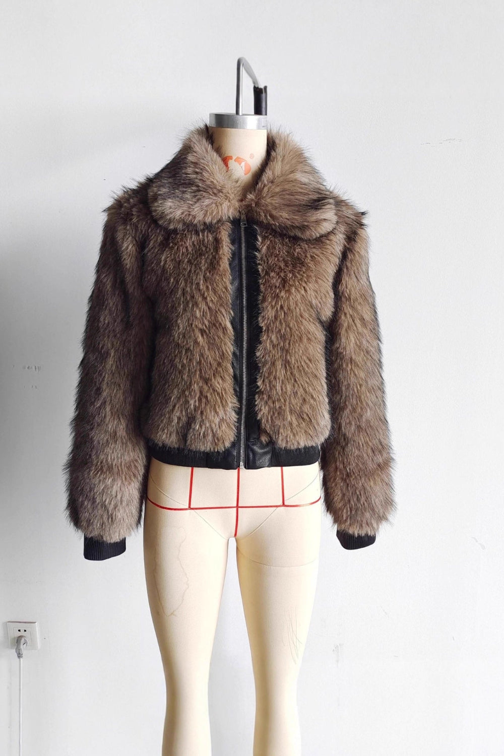 Brown fur jacket on a mannequin against a white background