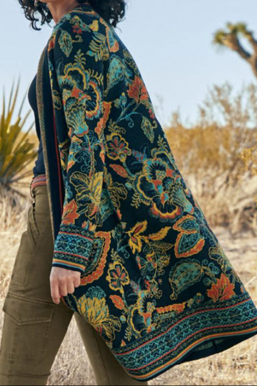 Person wearing a colorful patterned coat in a desert setting