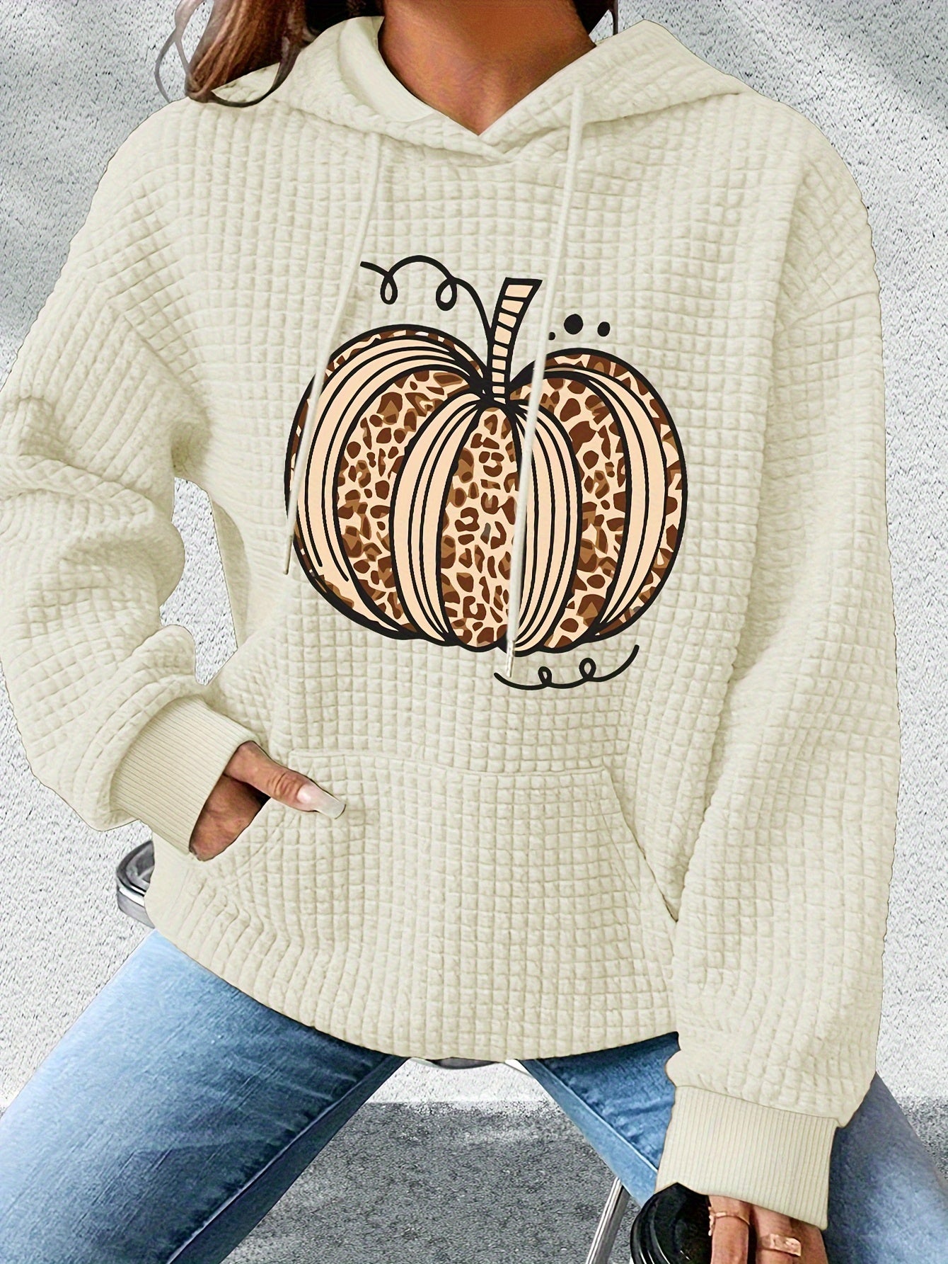Beige hoodie with leopard print pumpkin design on a gray background
