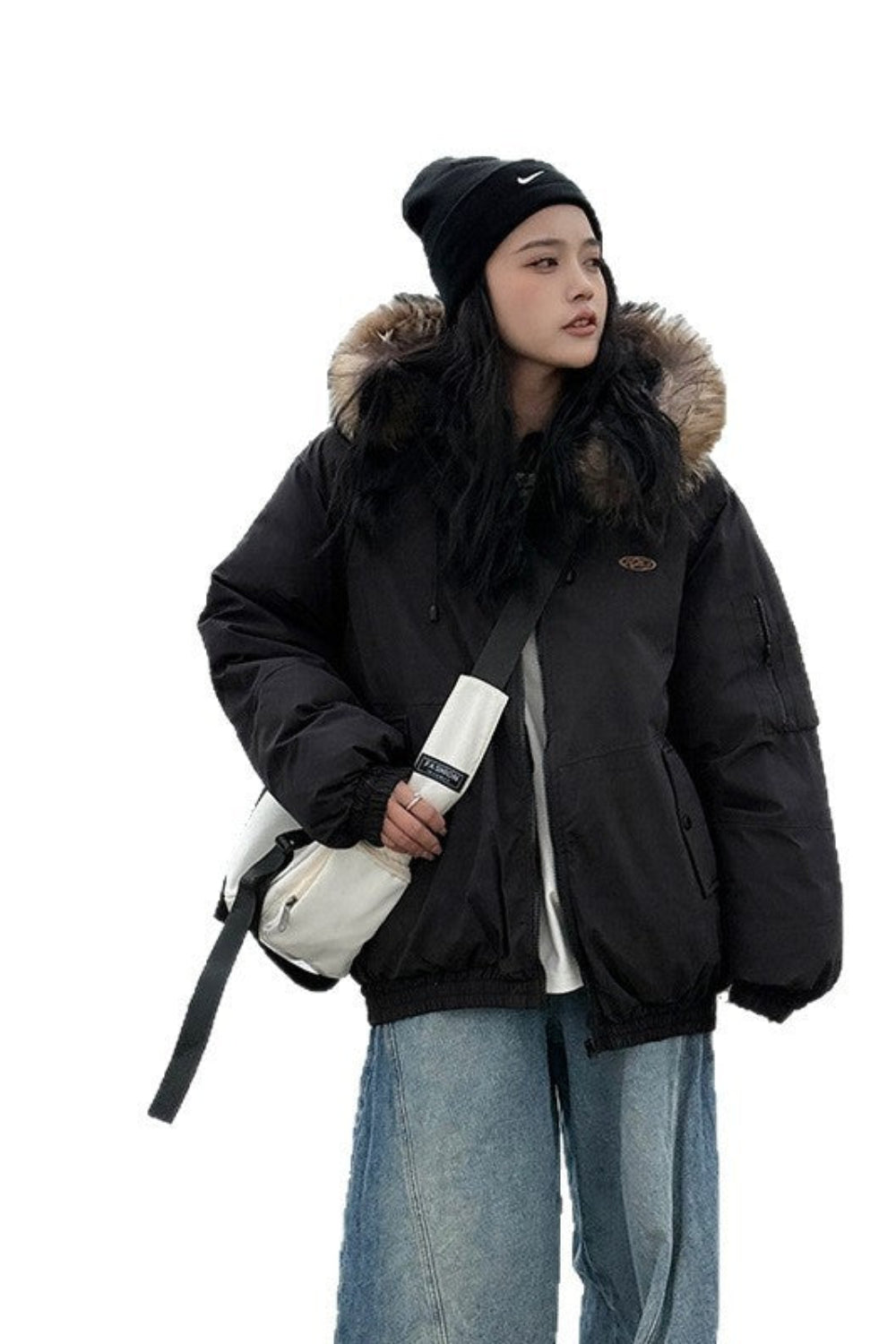 Person wearing a black winter jacket with fur hood on a white background