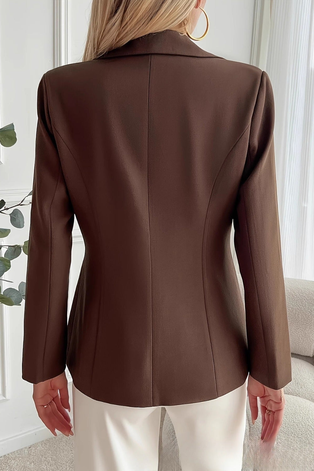 Brown blazer worn by a person in a neutral indoor setting