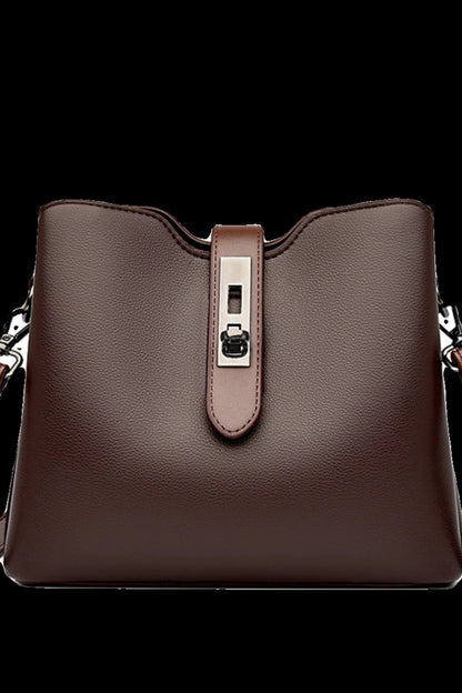 Brown leather handbag with a silver buckle on a white background