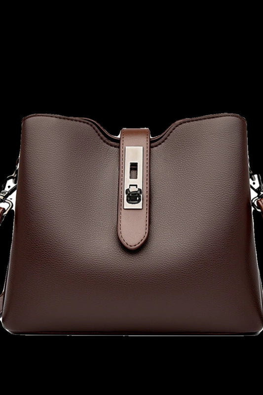 Brown leather handbag with a silver buckle on a white background