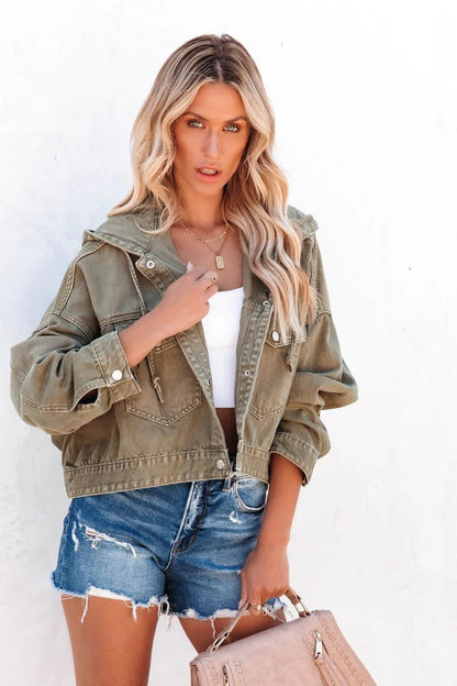 Woman wearing an olive green jacket and denim shorts against a white background