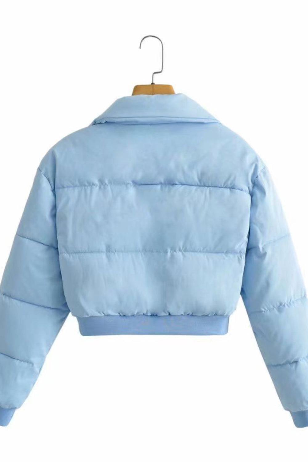 Light blue puffer jacket on a hanger against a white background