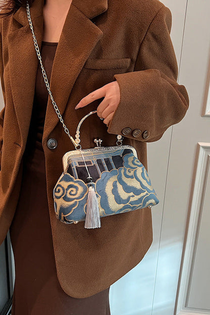 Person wearing a brown coat holding a blue and white patterned handbag.