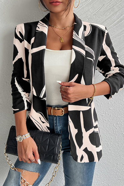 Woman wearing a black and white patterned blazer with a plain background