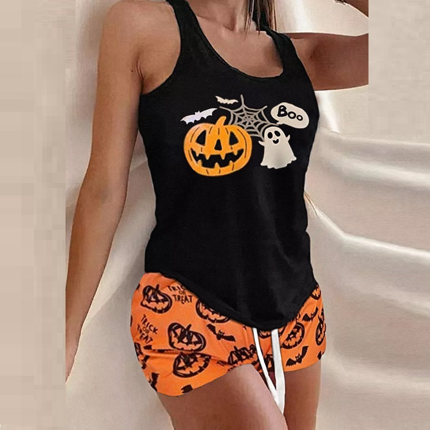 Black tank top with Halloween design and orange shorts with pumpkin pattern on a neutral background