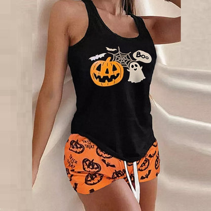 Black tank top with Halloween design and orange shorts with pumpkin pattern on a neutral background