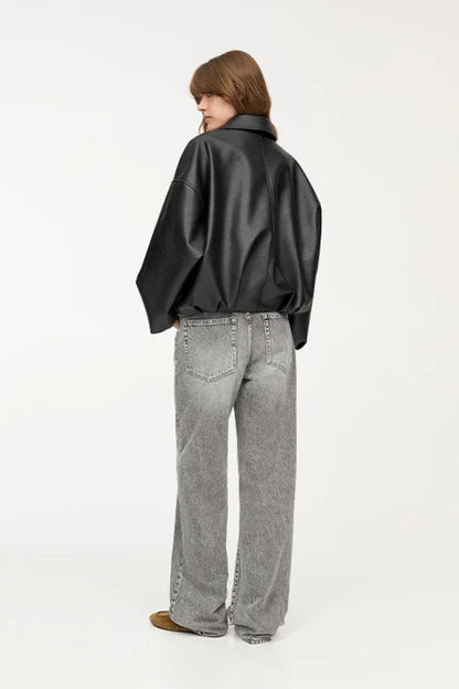 Person wearing a black shirt and gray jeans on a white background