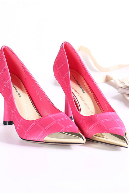 Pair of pink high-heeled shoes with gold toes on a white background