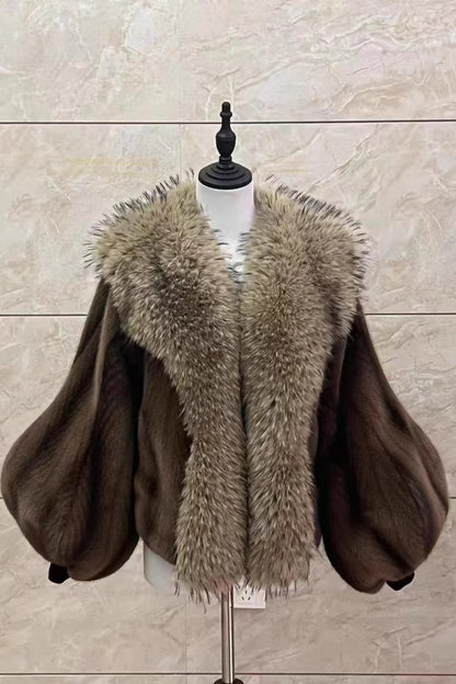 Brown fur coat with a fur collar on a mannequin against a beige tiled wall.