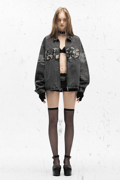 Person wearing a dark denim jacket with embroidery on a white background