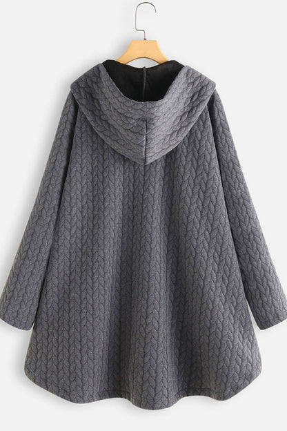 Gray quilted coat on a hanger against a white background