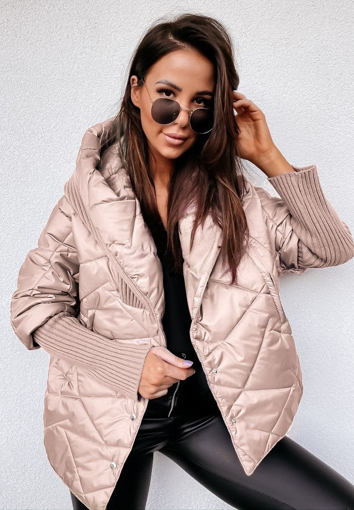Woman wearing a light pink quilted jacket against a white background