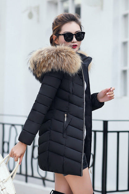 Woman wearing a black puffer coat with fur hood in an urban setting