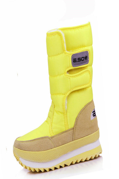 Yellow winter boot with beige sole on a white background