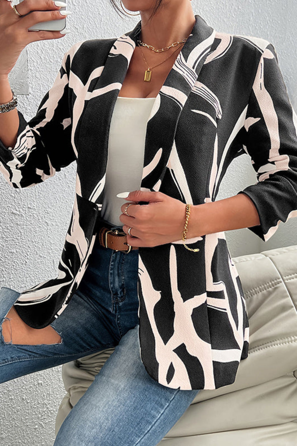 Person wearing a black and white patterned shirt sitting on a couch.