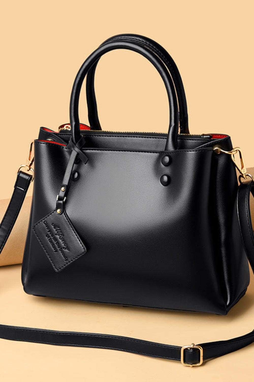 Black handbag with a strap on a beige background