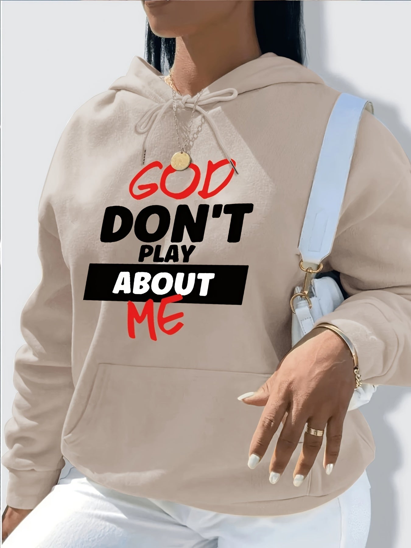 Beige hoodie with text 'GOD DON'T PLAY ABOUT ME' worn by a person.