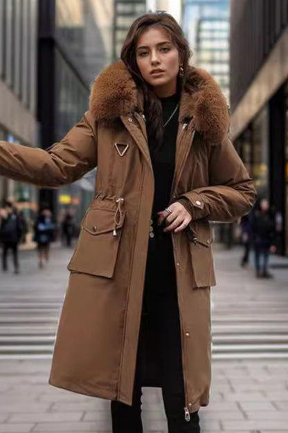 Woman wearing a brown coat with fur hood on a city street
