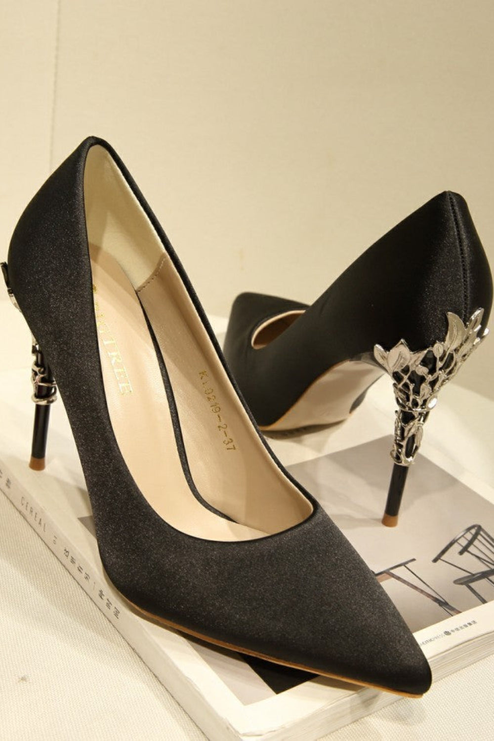 Black high-heeled shoes with decorative heel on a magazine