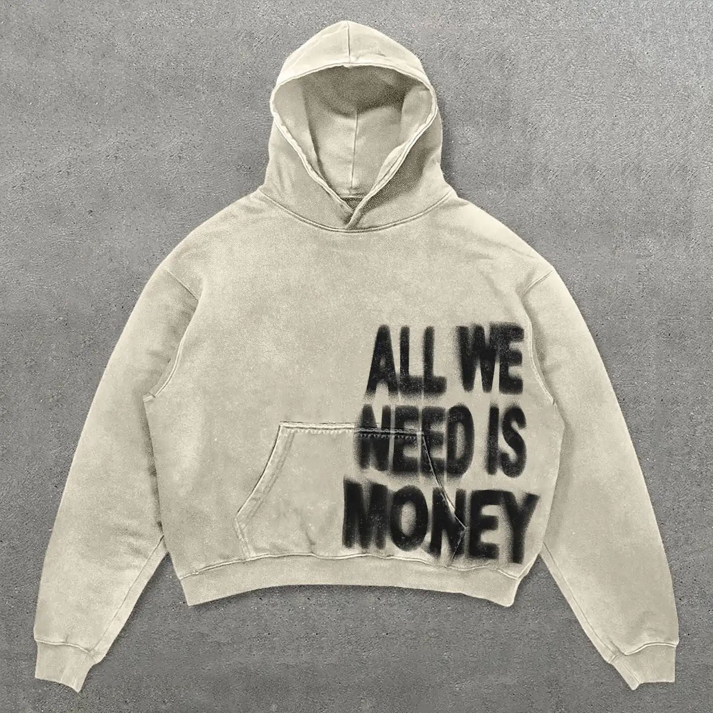 Beige hoodie with 'All We Need Is Money' text on a gray background