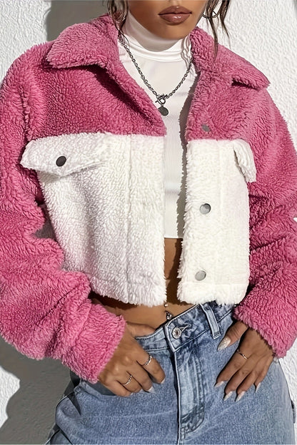 Person wearing a pink and white fleece jacket with blue jeans against a white background