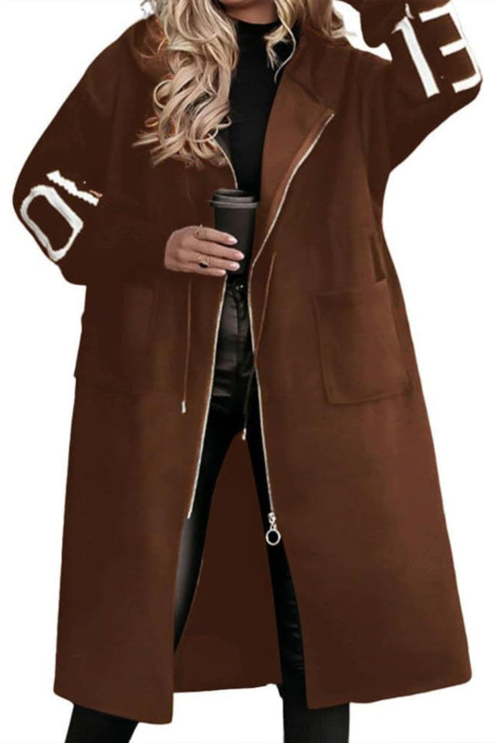 Brown coat with lettering on sleeves worn by a person holding a coffee cup.