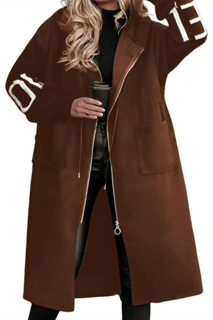 Brown coat with lettering on sleeves worn by a person holding a coffee cup.