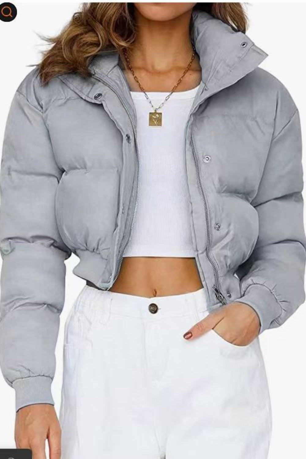 Person wearing a gray puffer jacket over a white top and pants on a white background