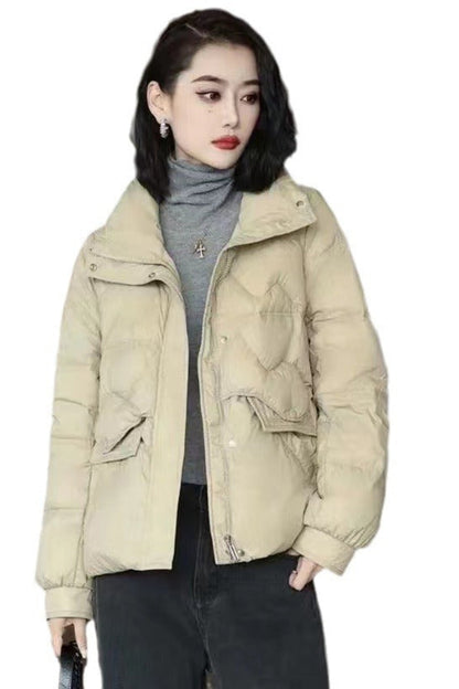 Woman wearing a beige puffer jacket on a white background