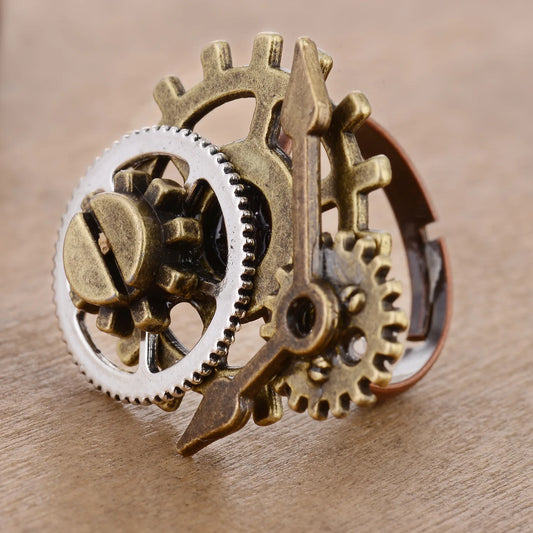 Close-up of a steampunk-style ring with gears on a wooden surface