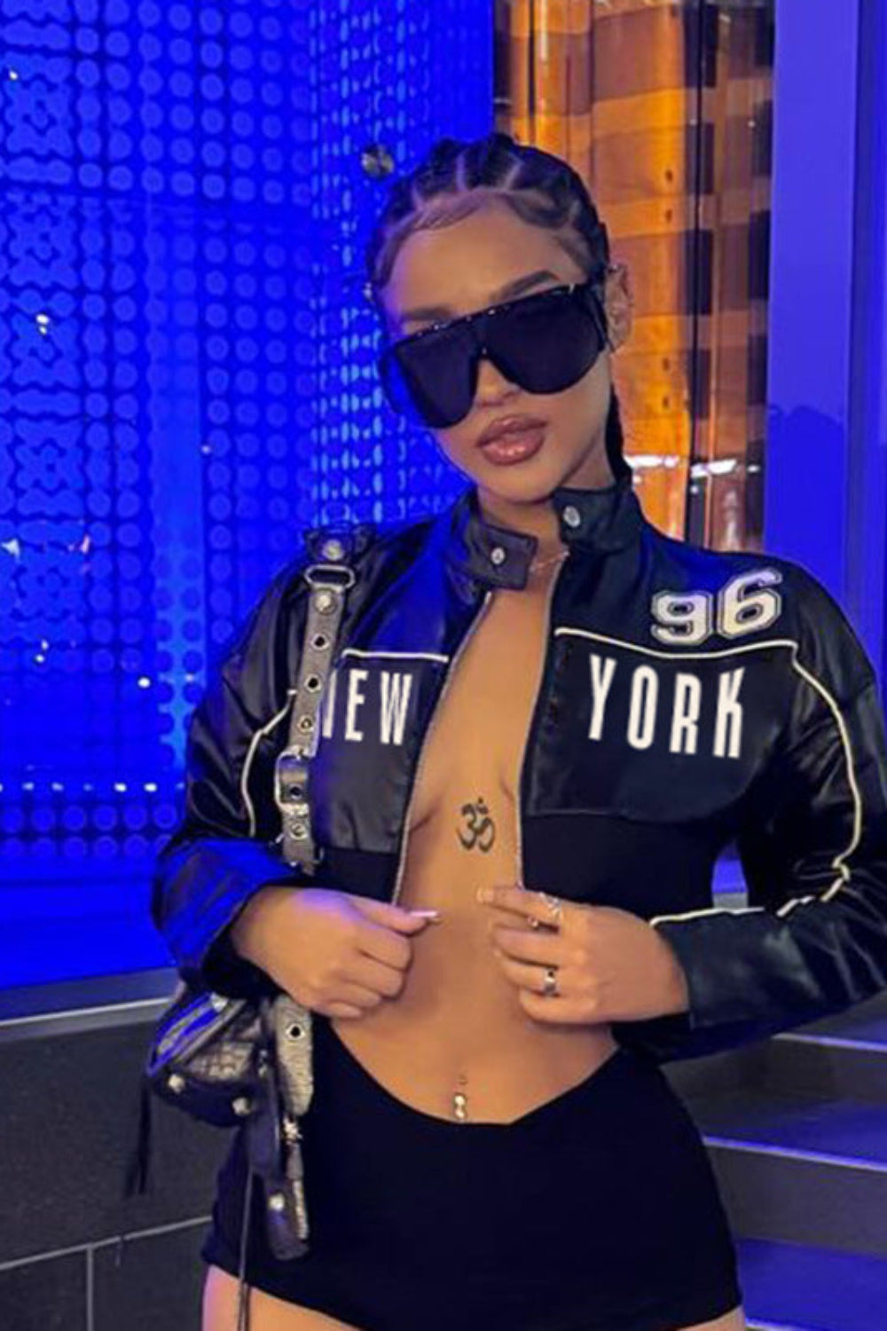 Person wearing a black 'New York' jacket with a blue background