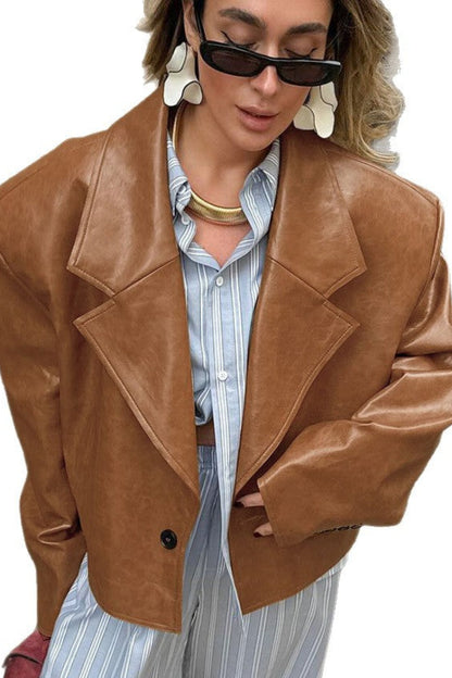 Person wearing a brown leather jacket over a striped shirt on a white background