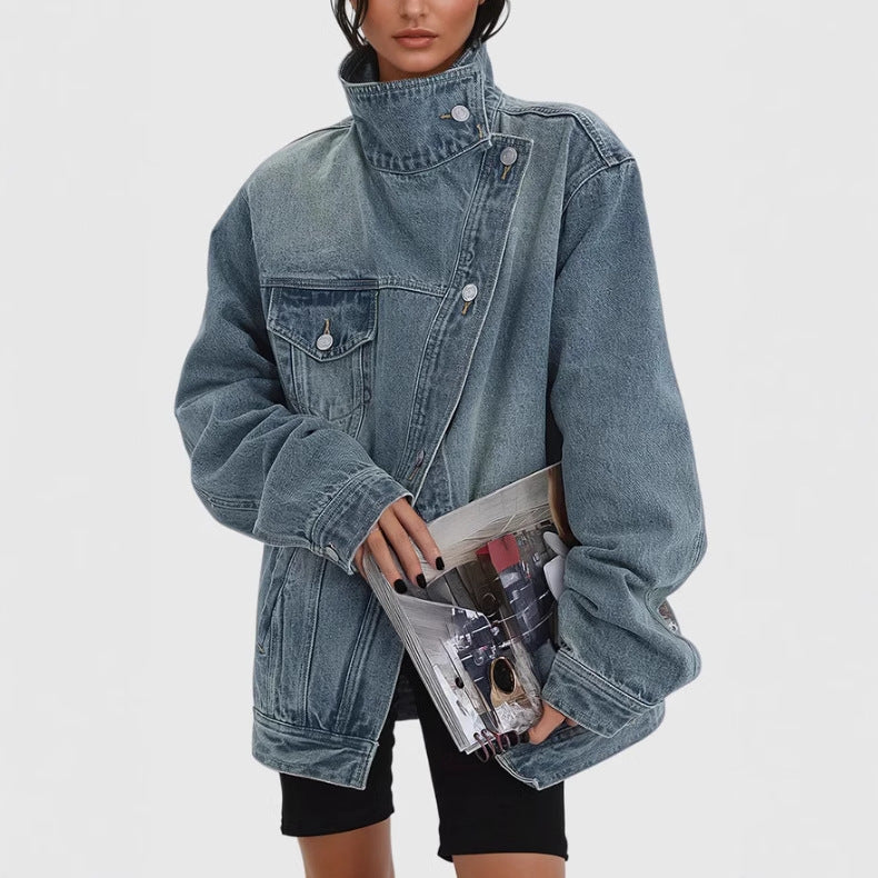 Person wearing an oversized denim jacket holding a clear clutch with colorful items on a white background
