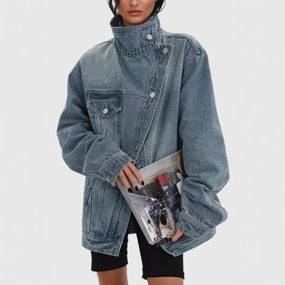 Person wearing an oversized denim jacket holding a clear clutch with colorful items on a white background