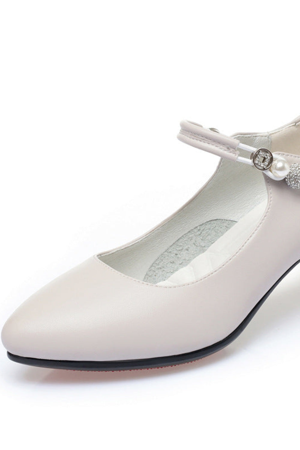 White shoe with a pearl embellishment on a white background
