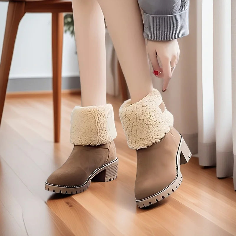 Brown ankle boots with white fur trim worn indoors on a wooden floor.