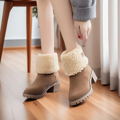 Brown ankle boots with white fur trim worn indoors on a wooden floor.