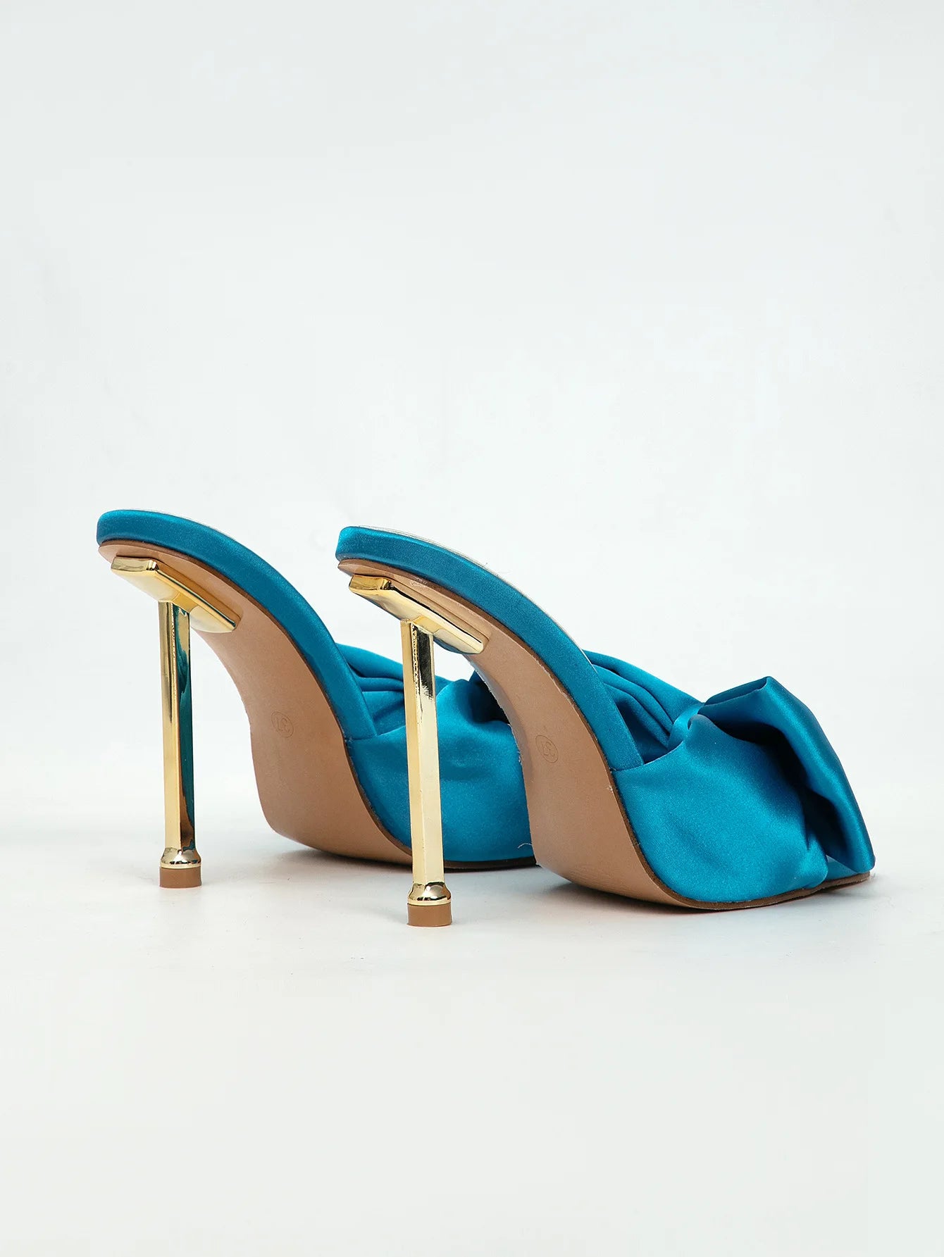 Blue high-heeled shoes with gold heels on a white background