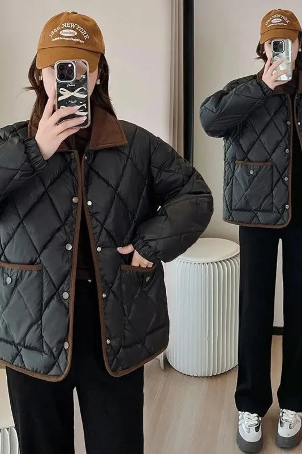 Person wearing a black quilted jacket with brown accents, taking a mirror selfie.
