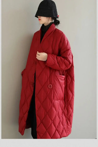 Person wearing a long red quilted coat against a plain background